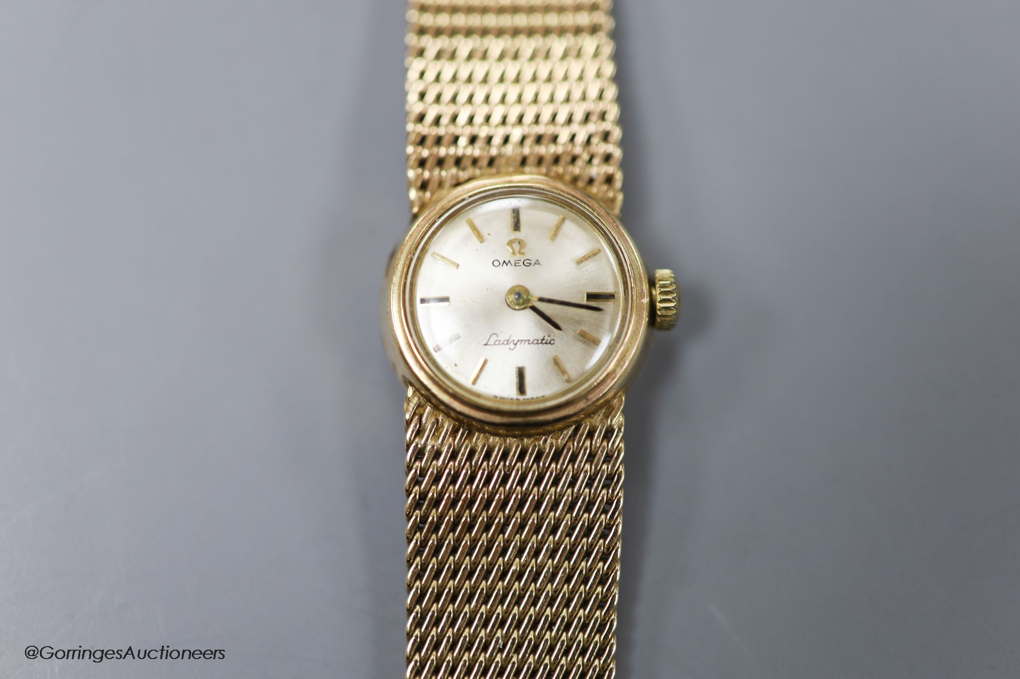 A lady's 9ct gold Omega Ladymatic wrist watch on integral 9ct gold Omega bracelet